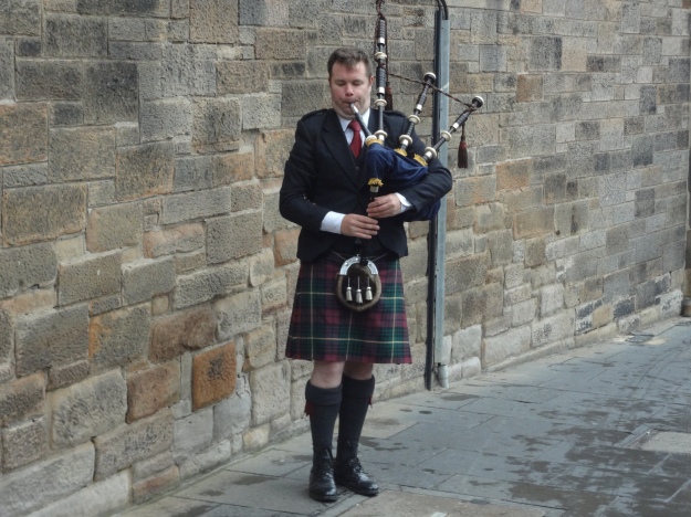 A bagpiper pipes a lively tune outside Edinburgh Castle in Scotland.